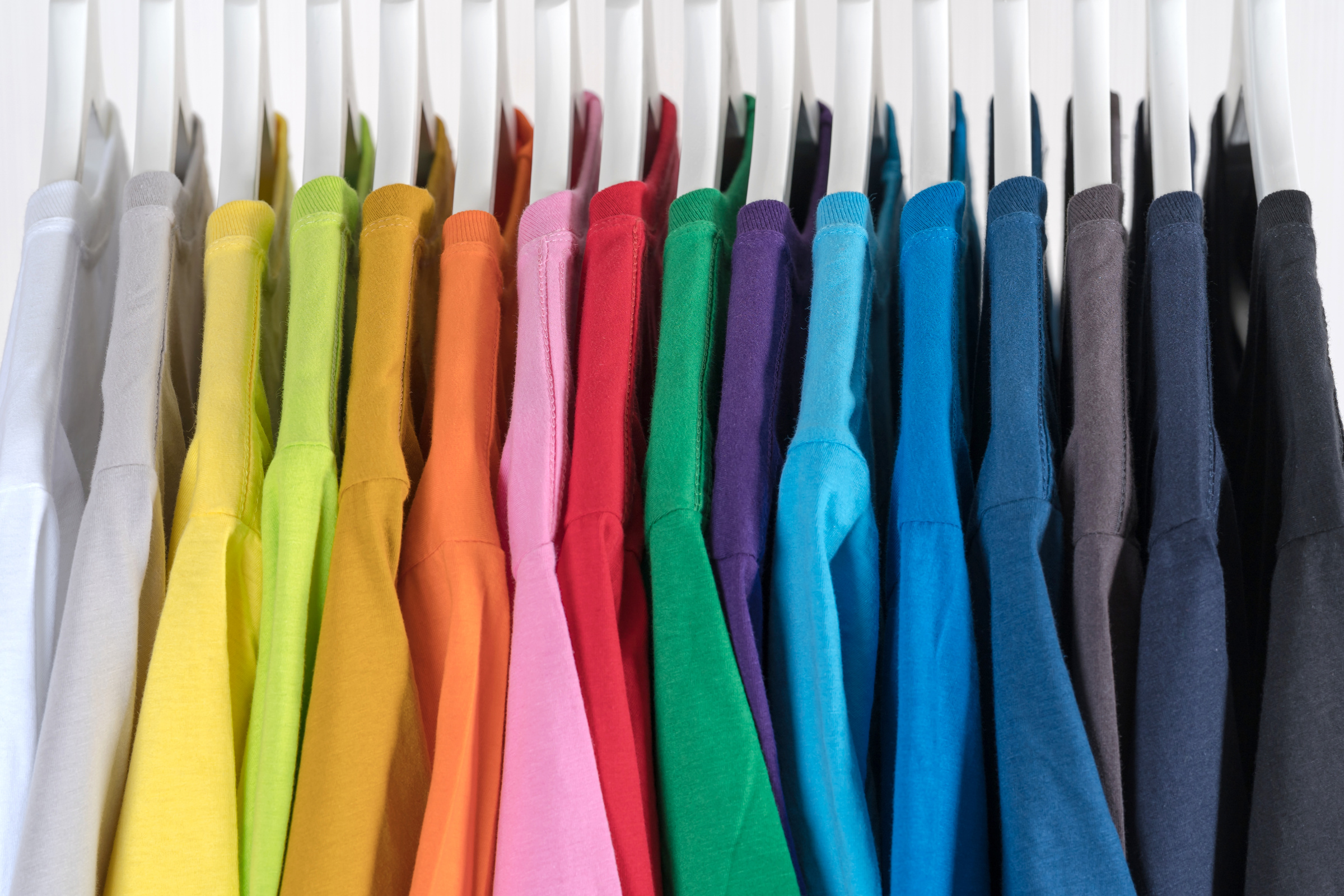 Stylish collection of multicolored clothes on hangers in boutique